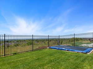 Expansive outdoor area featuring a black metal fence enclosing a grassy yard