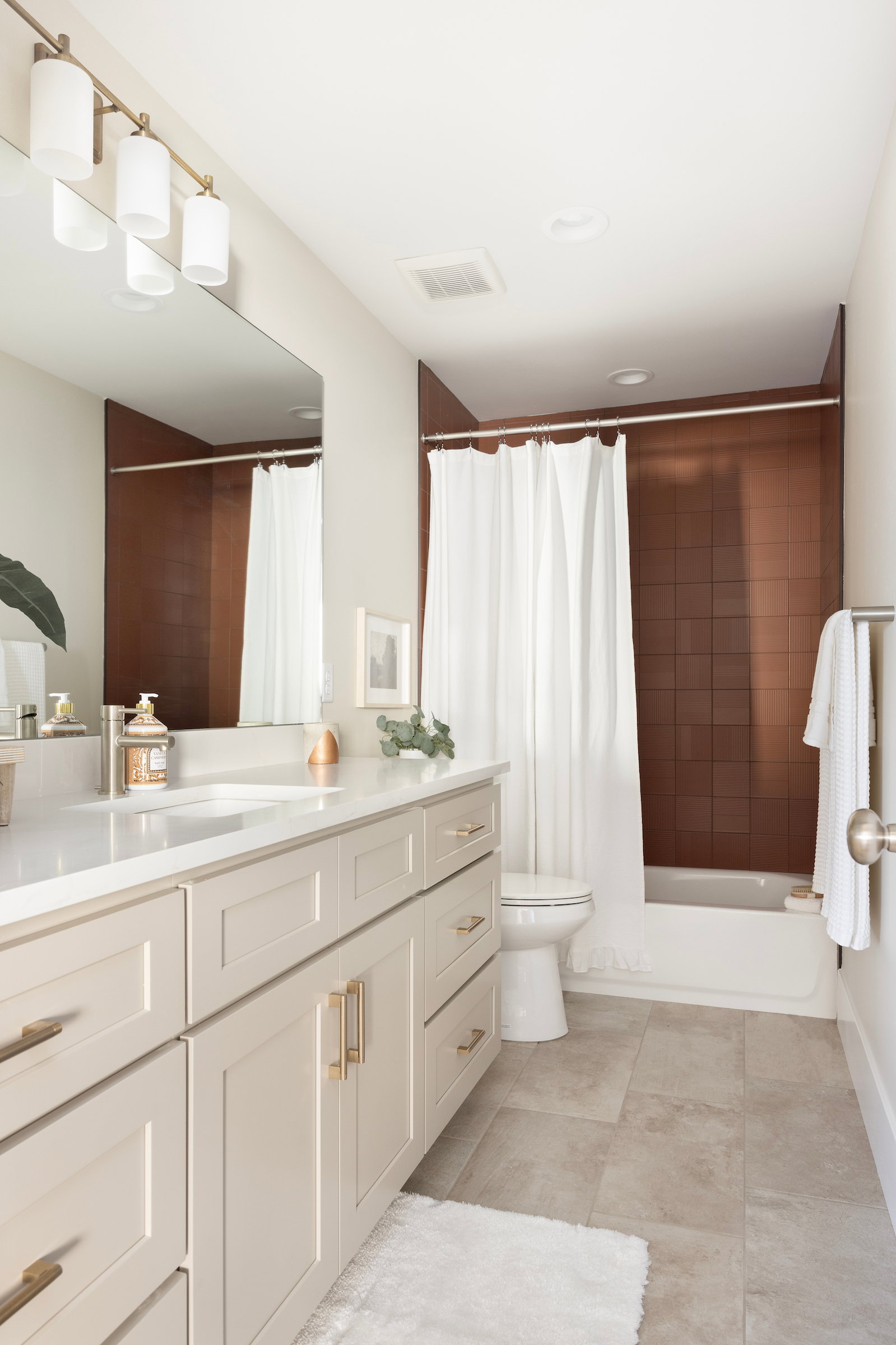 Bathroom featuring a long vanity with light-toned cabinetry, a built-in rectangular sink, and a light-colored countertop