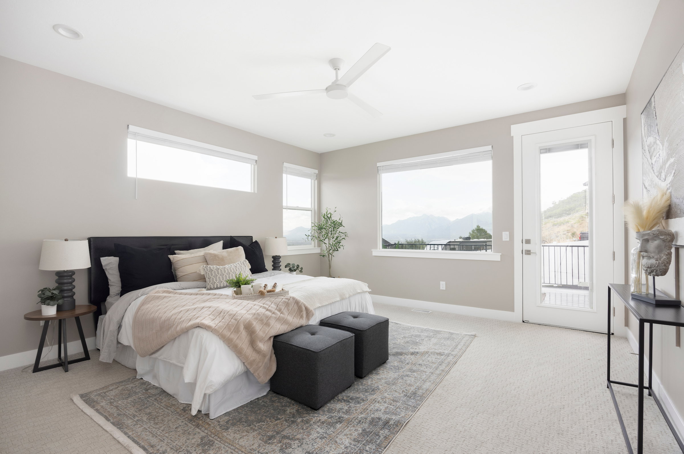 Spacious room featuring broad windows with mountain scenery, a glass-paneled exterior door, neutral-toned carpeting, and recessed ceiling lighting