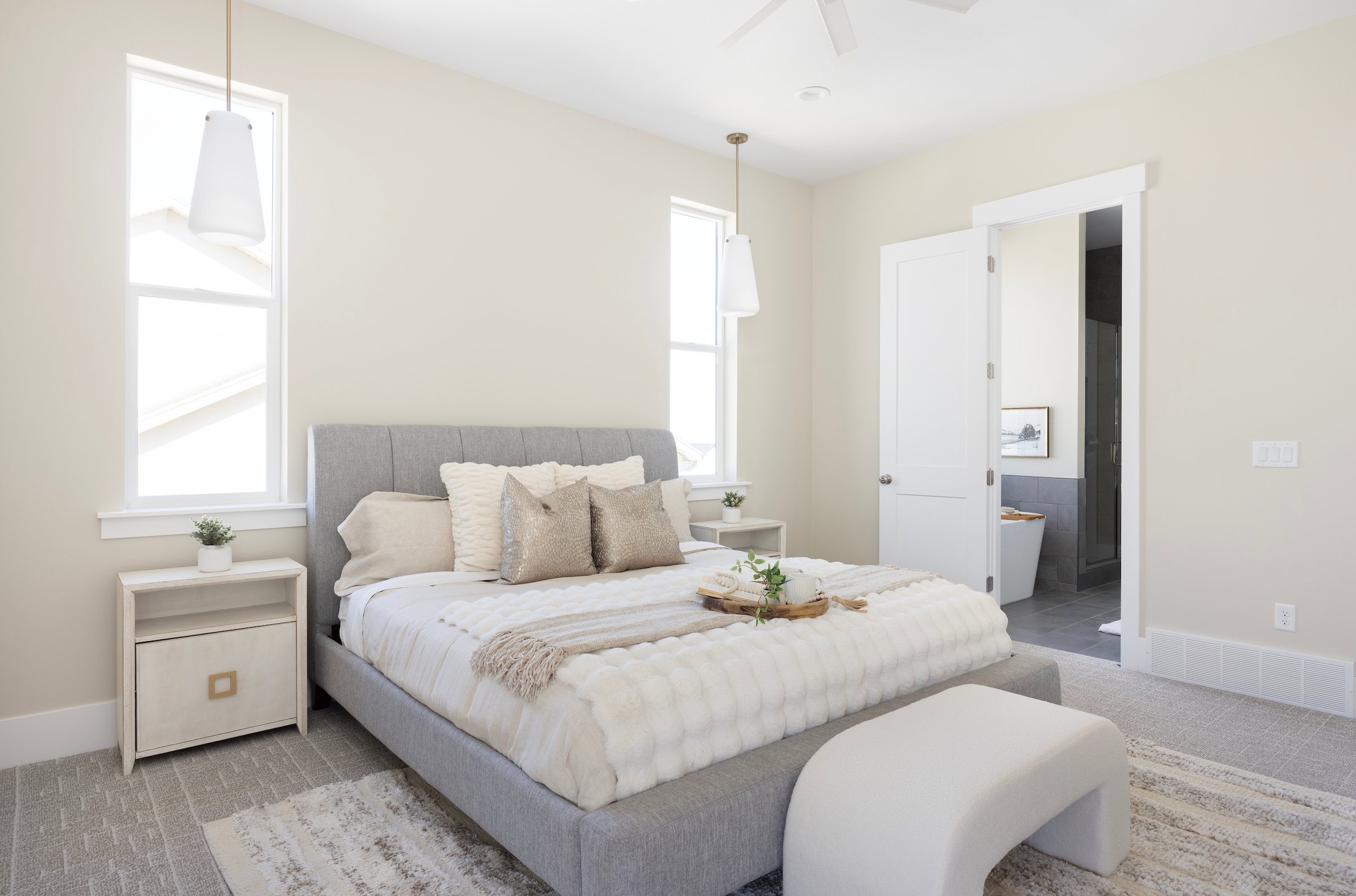 Bedroom featuring two tall windows, flush-mounted ceiling fan, pendant lighting, and neutral wall tones