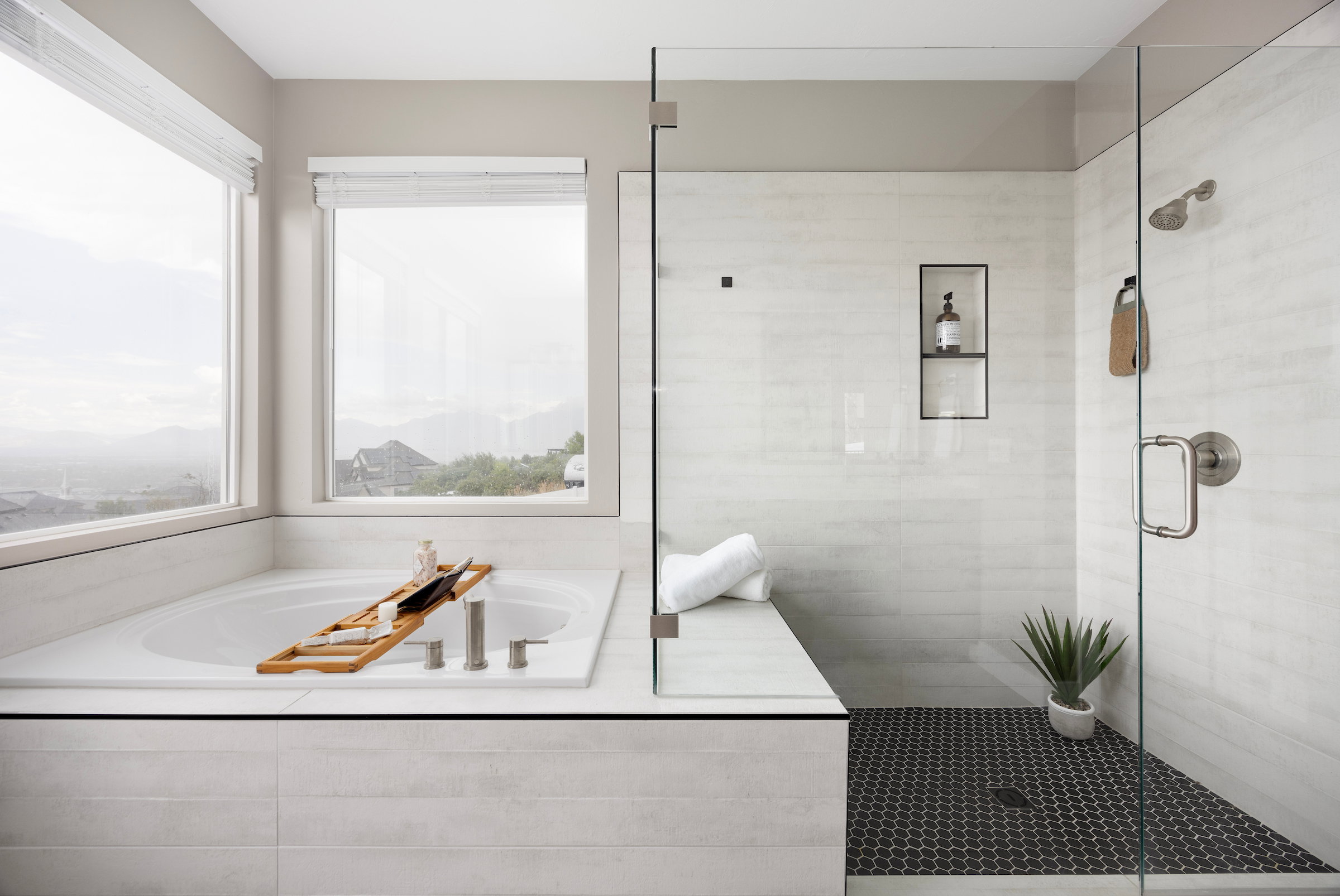 Expansive soaking tub with deck-mounted fixtures, set beneath multiple windows
