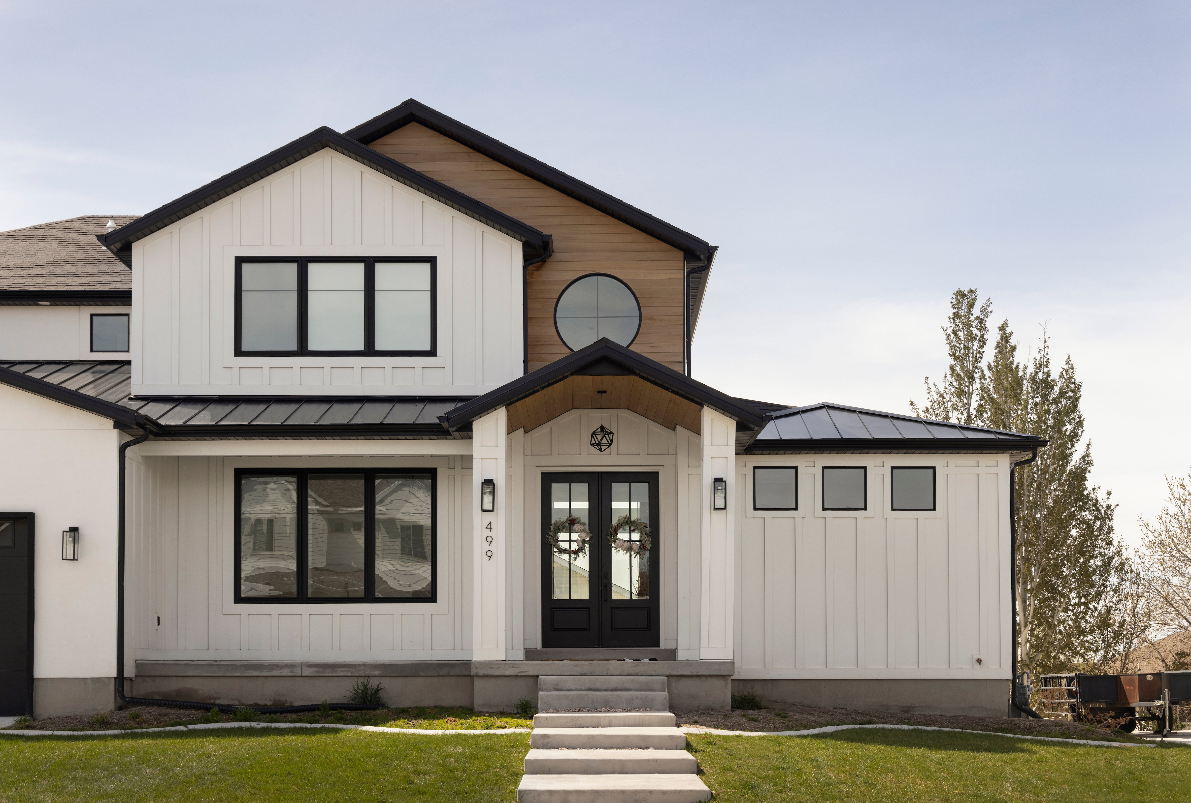 Modern Farmhouse exterior featuring white board and batten siding and a wood-finish accent