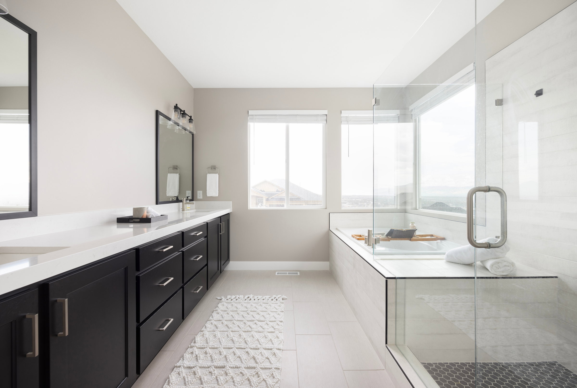 Spacious bathroom featuring a dual vanity with white countertops, dark cabinetry, and integrated sinks