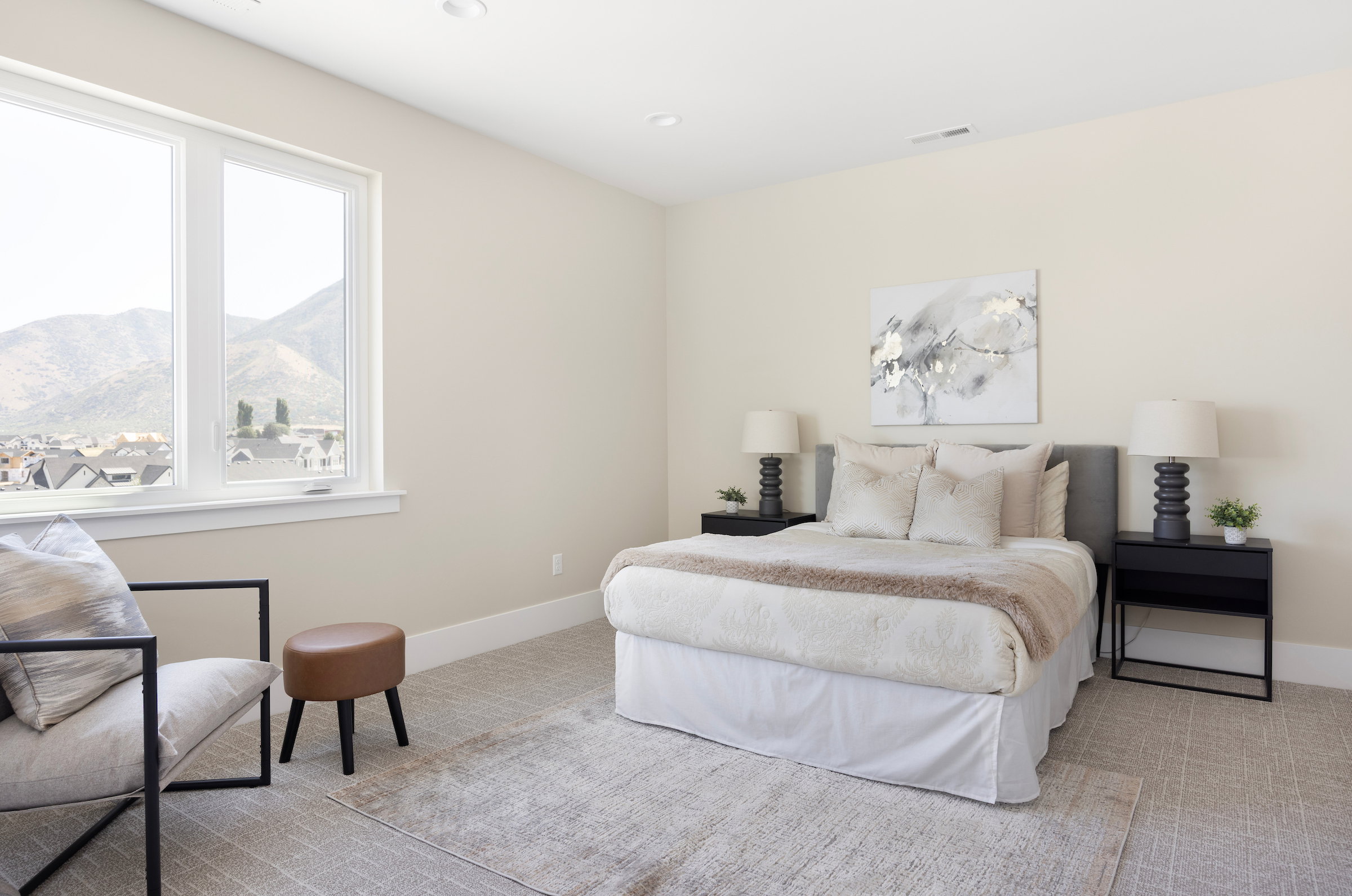 Bright room featuring a large window with mountain scenery, plush carpeting, recessed lighting, and a neutral color palette