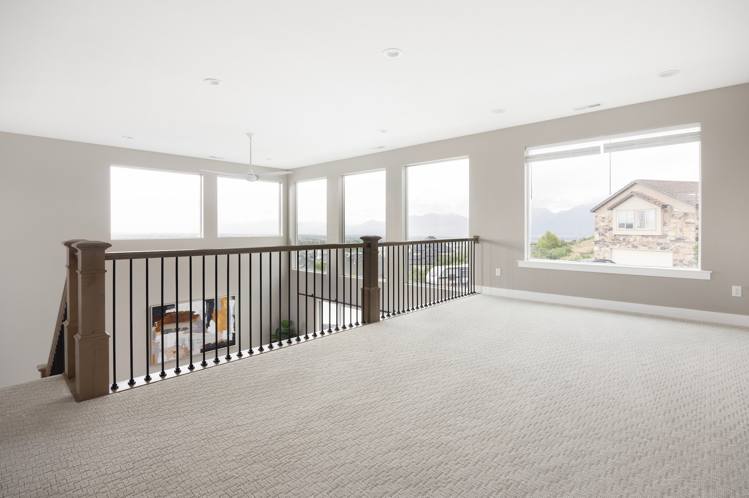 Spacious upper-level loft featuring light-toned carpeting and neutral wall paint