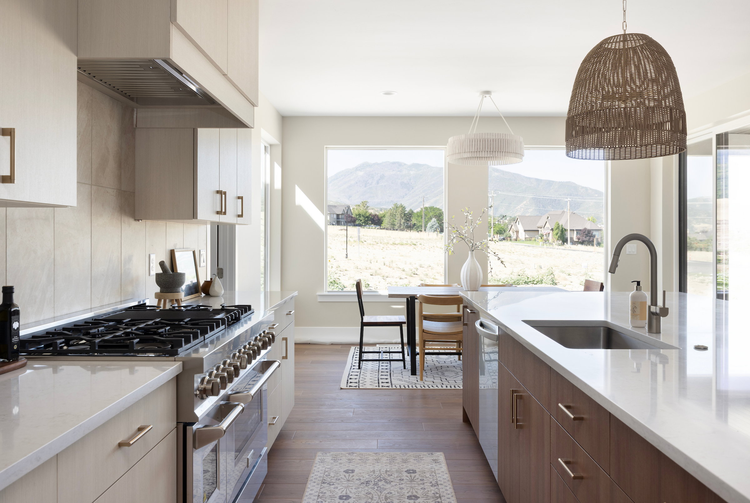 Gourmet kitchen featuring a professional-grade gas range with stainless steel hood, expansive countertop space, and dual-tone cabinetry