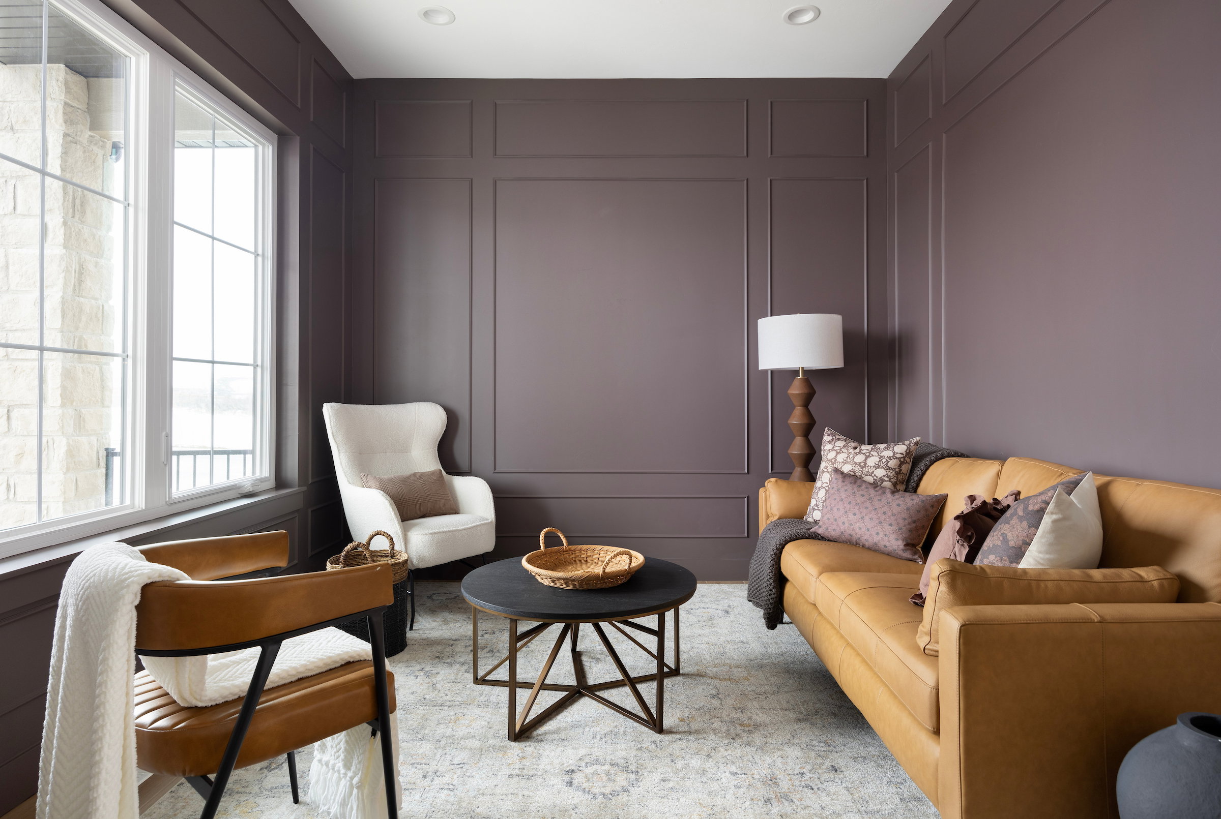 Panel molding accentuates the wall in this living space, complemented by recessed lighting