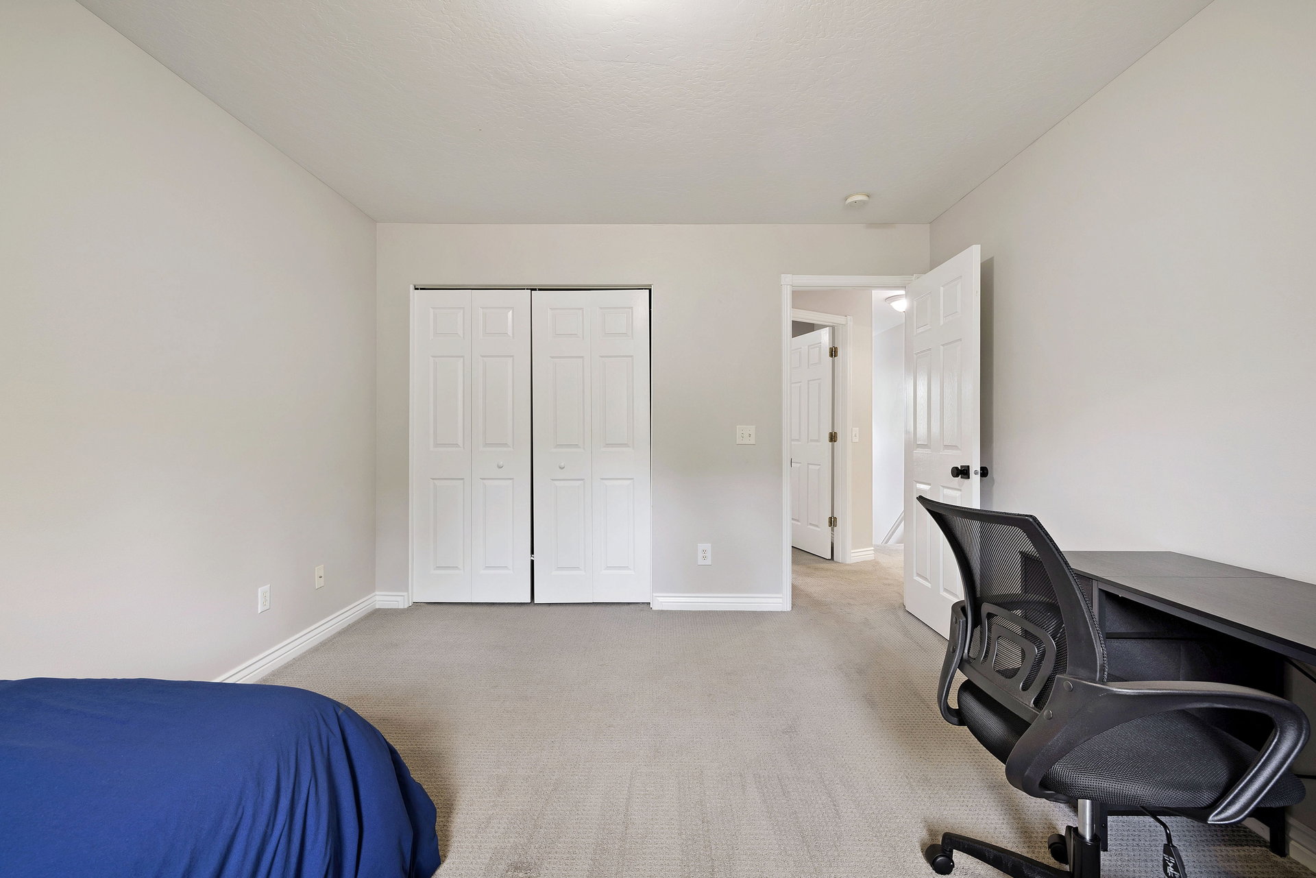 Neutral wall paint with white trim, light gray carpeting, and bi-fold closet doors