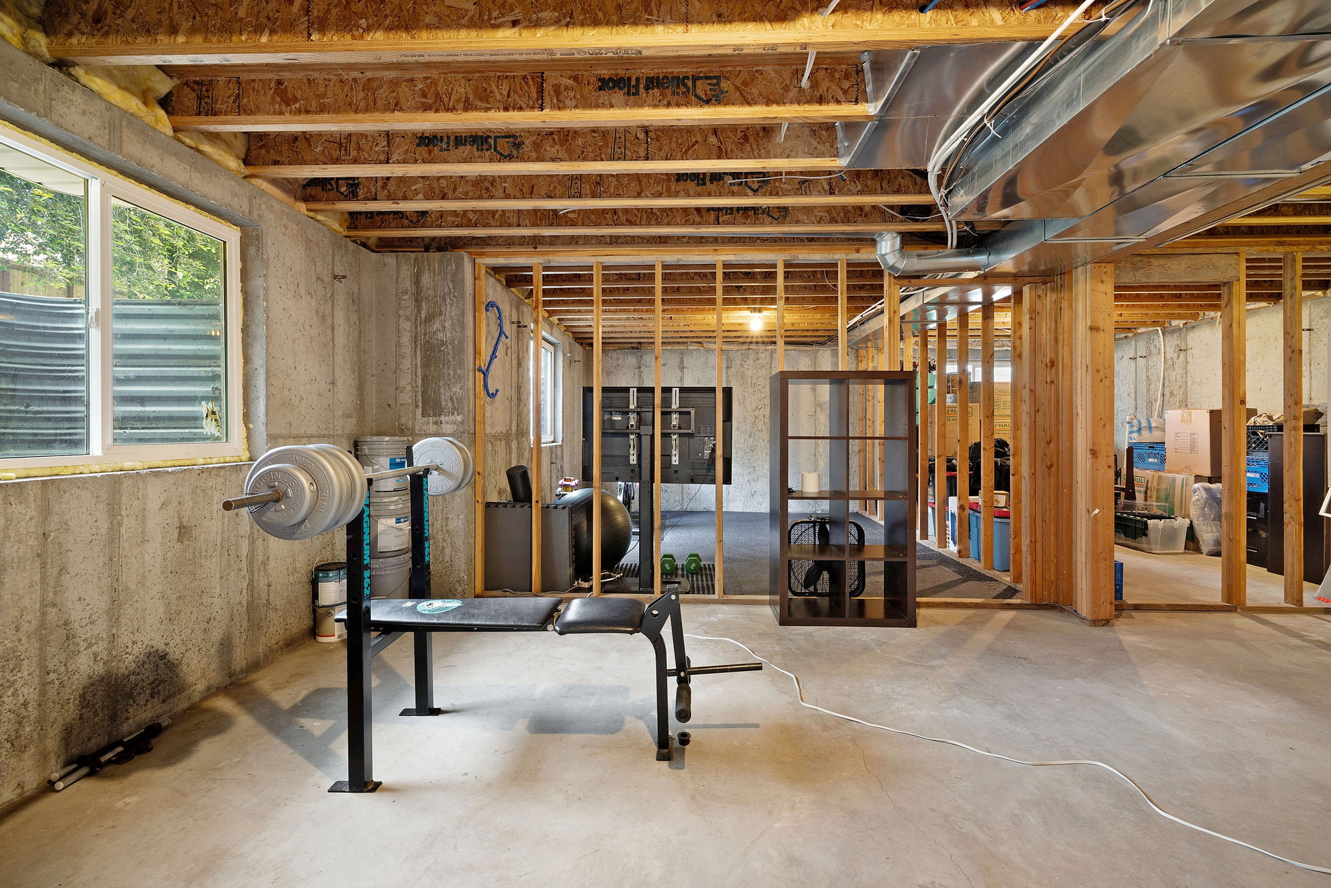 Unfinished basement with concrete flooring and exposed ceiling joists