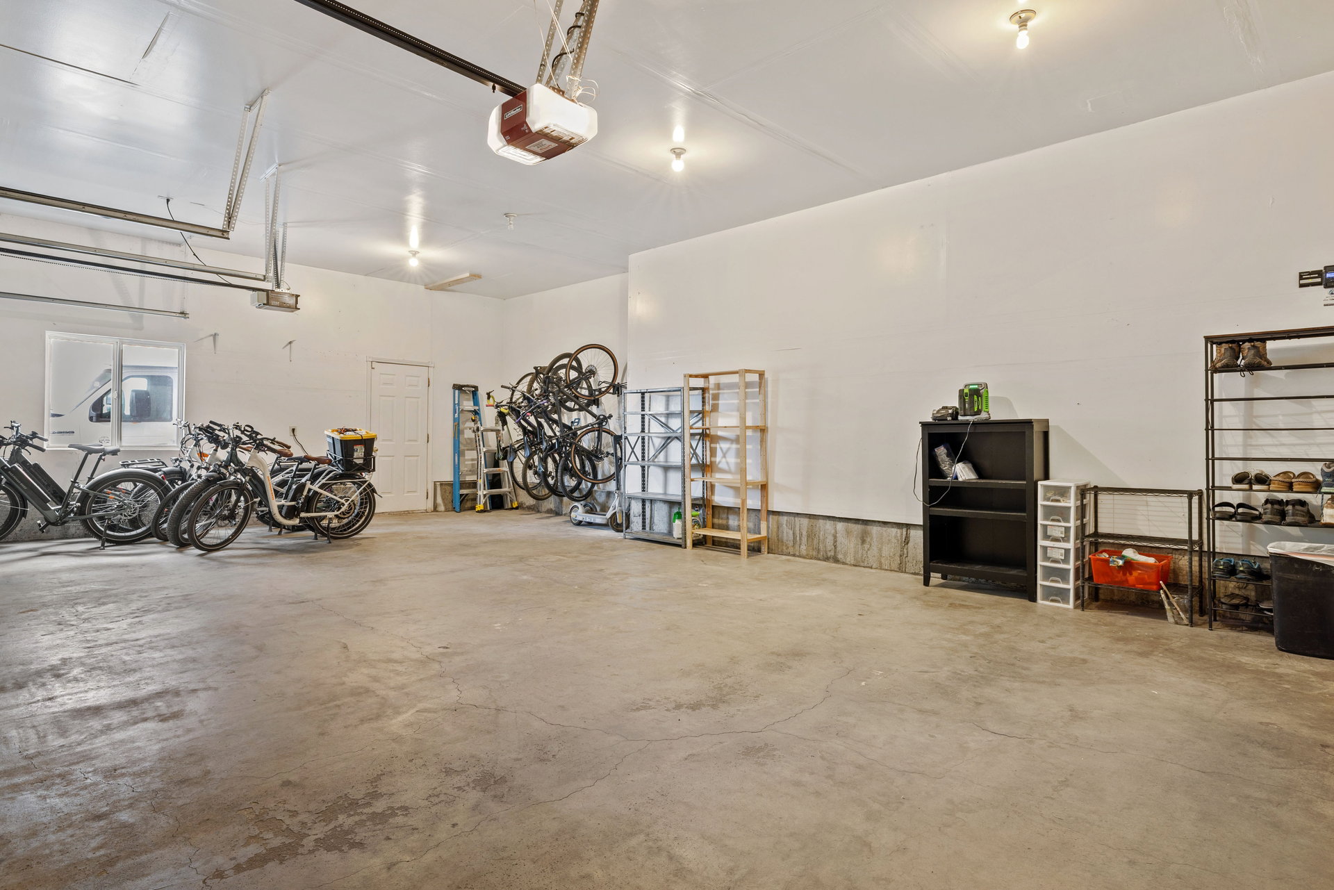 Expansive garage featuring concrete flooring, white painted walls, and overhead lighting