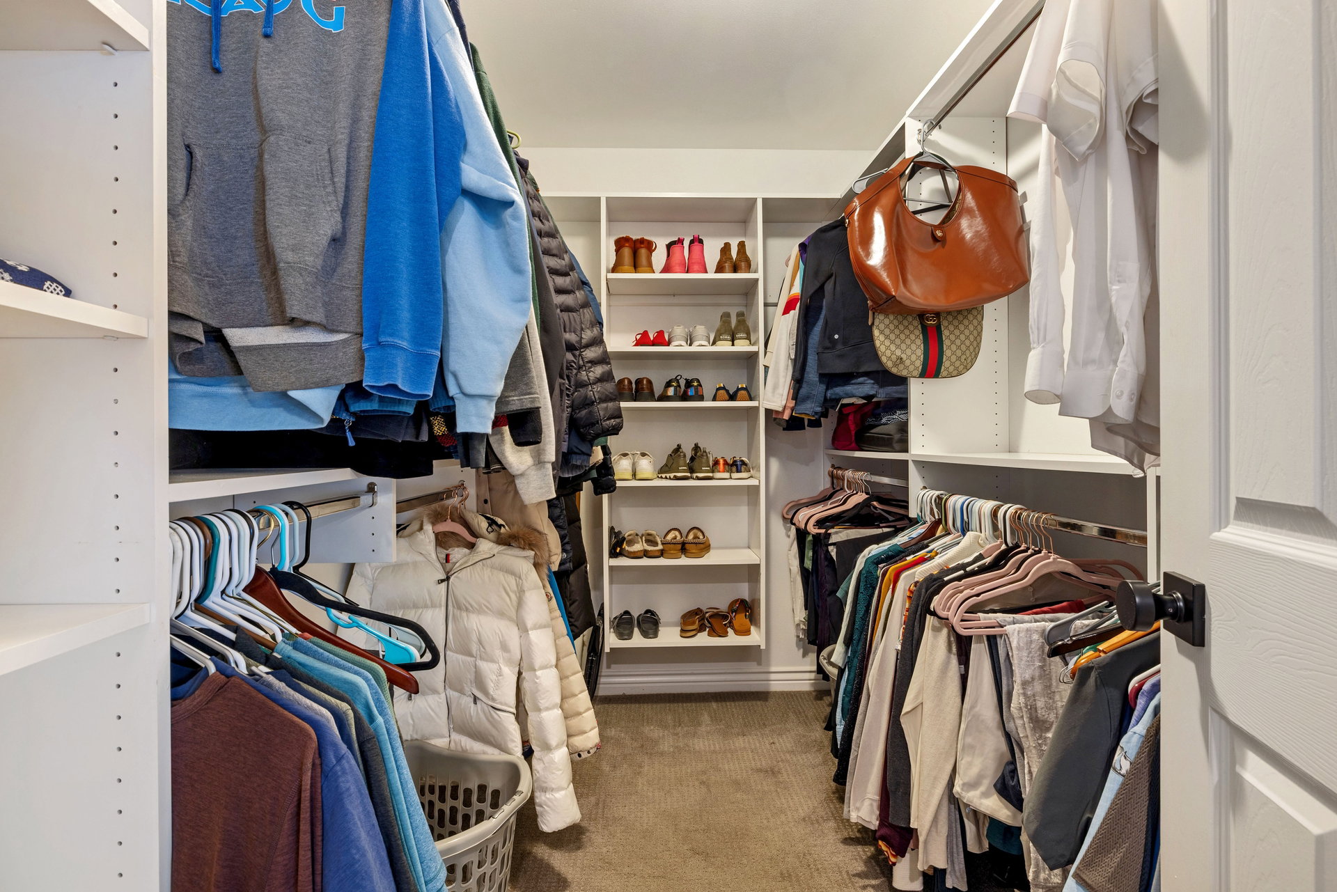 Custom closet system featuring extensive shelving and multiple hanging rods