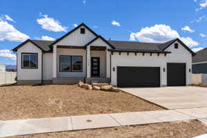 Contemporary ranch-style residence featuring white horizontal siding, black trim accents, a two-car garage with black doors, a covered front entry, and a concrete driveway