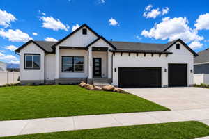Contemporary ranch-style home featuring white horizontal siding, black trim, and a prominent two-car garage with black doors