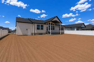 Expansive tilled backyard with a modern white siding exterior
