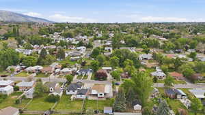 Expansive residential area featuring a diverse collection of single-family homes, mature trees, and a mountain backdrop