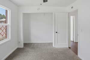 Room featuring neutral-toned carpeting, white walls, and a window with white trim