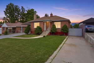 Brick exterior with a peaked roofline, front porch, and mature landscaping
