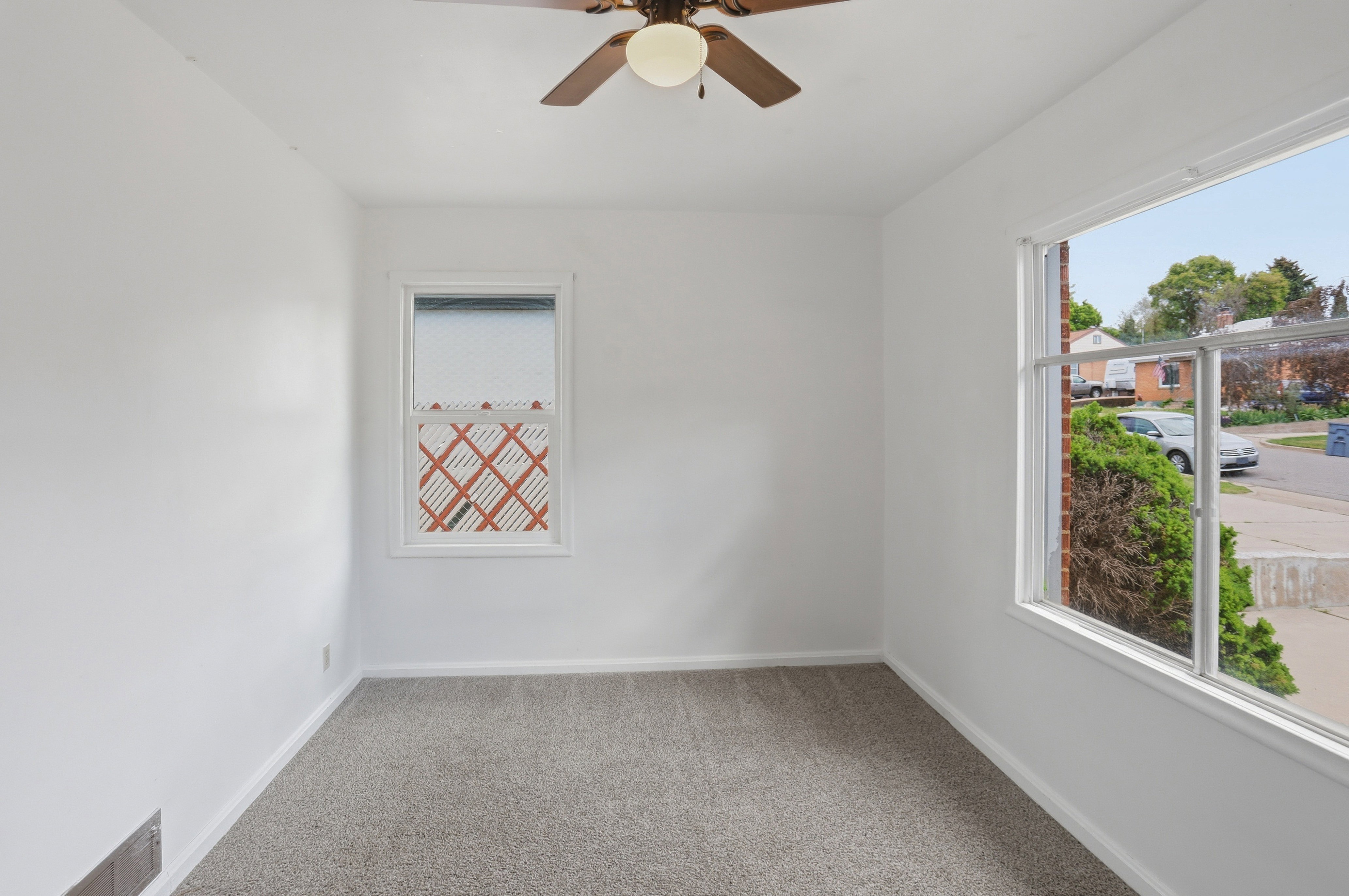 Room featuring neutral carpeting, white painted walls, and a ceiling fan with integrated lighting