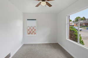 Room featuring neutral carpeting, white painted walls, and a ceiling fan with integrated lighting