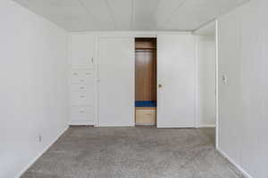 Interior room featuring light gray carpet flooring, white painted walls, and a white paneled ceiling