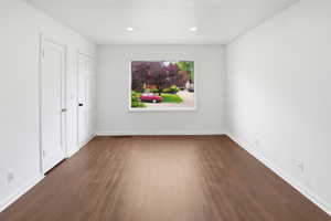 Spacious room featuring wood-finish flooring and bright white walls