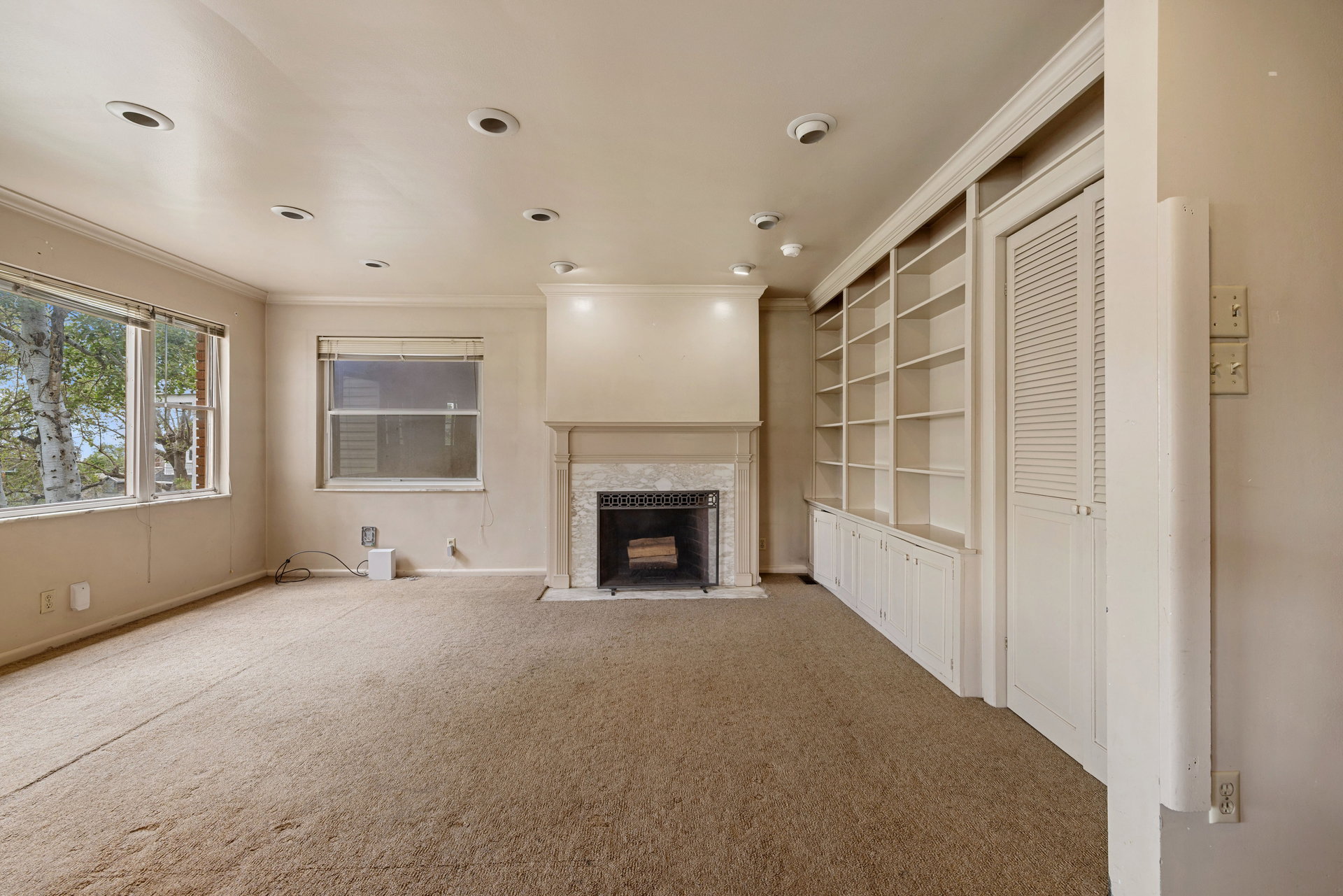 Living area featuring a fireplace with a stone surround and a substantial mantle
