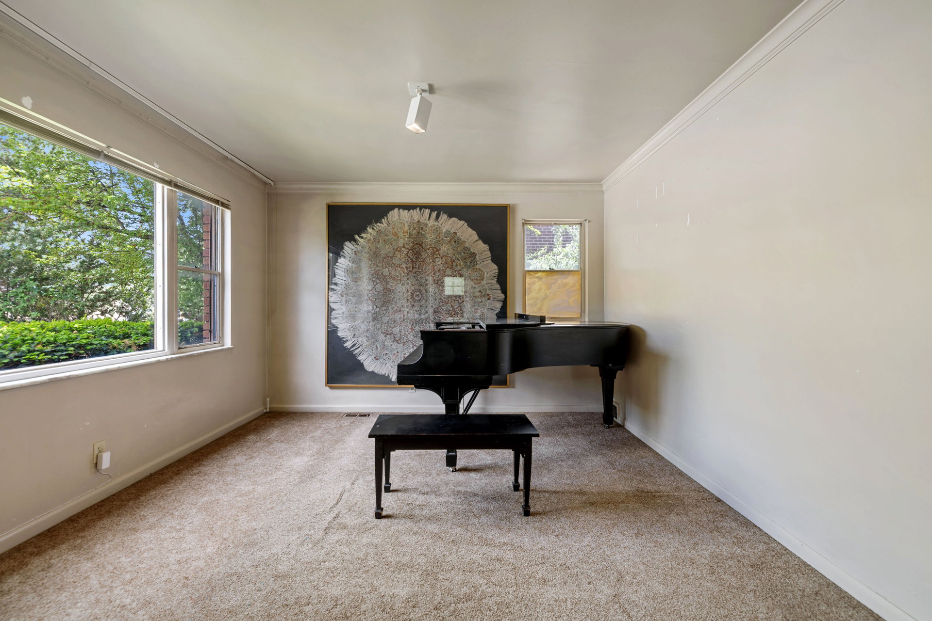Carpeted interior space featuring light-toned walls and crown molding
