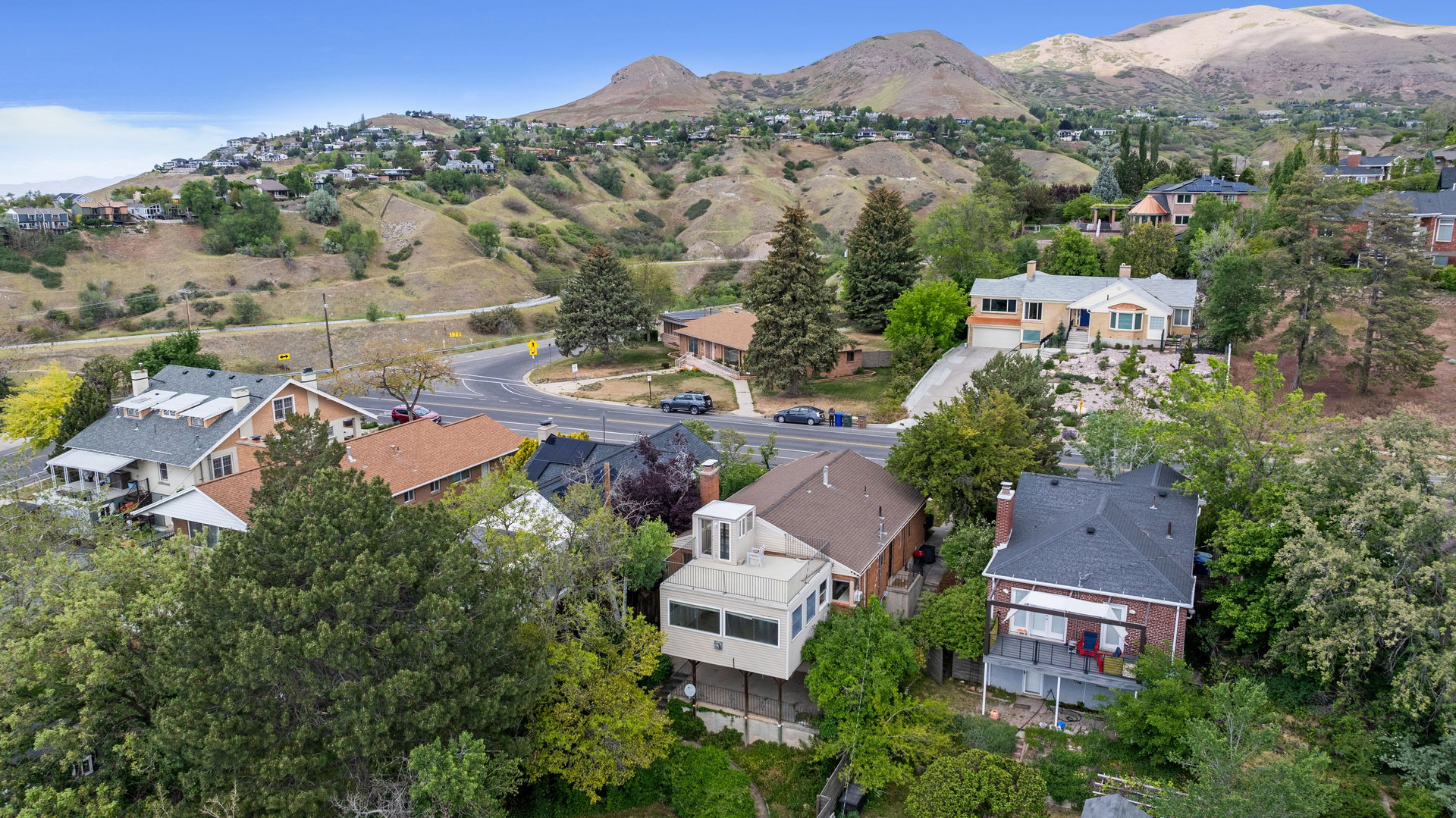 Expansive aerial perspective showcasing a residential area nestled against a mountainous backdrop