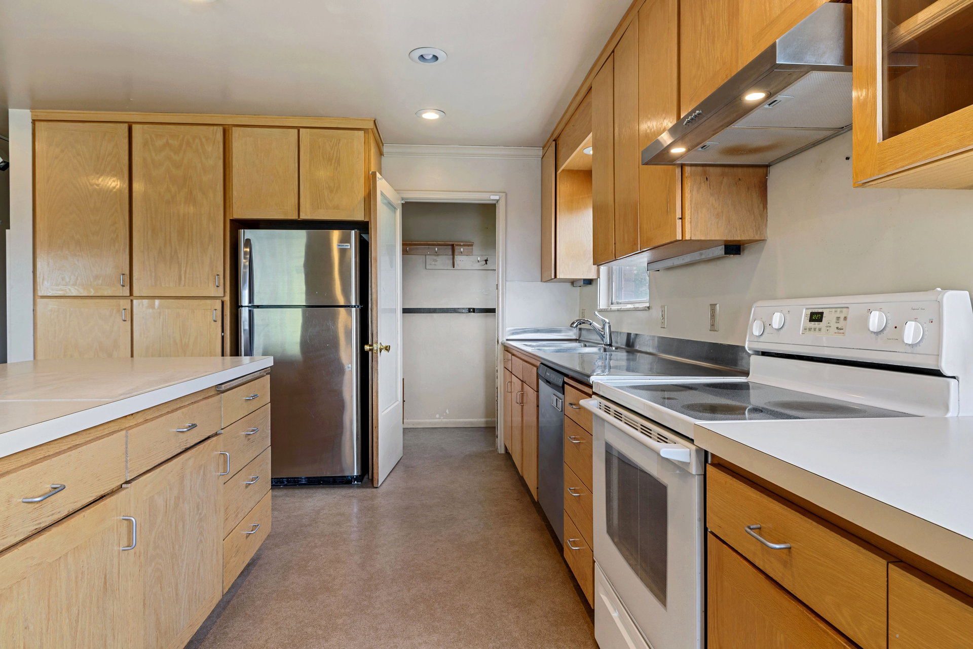 Kitchen featuring light wood cabinetry, white countertops, stainless steel refrigerator, white electric range, and recessed lighting