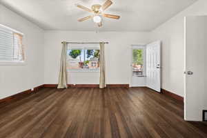 Spacious room featuring rich wood-finish flooring and a ceiling fan with integrated lighting