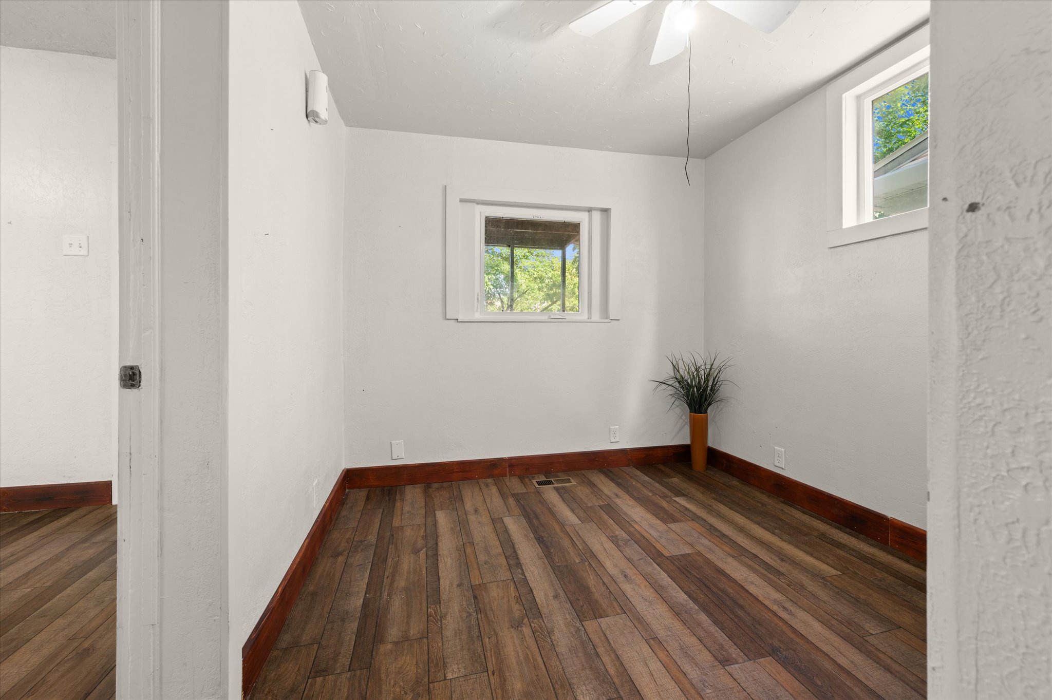 Room featuring wood-finish flooring, white walls, and white trim