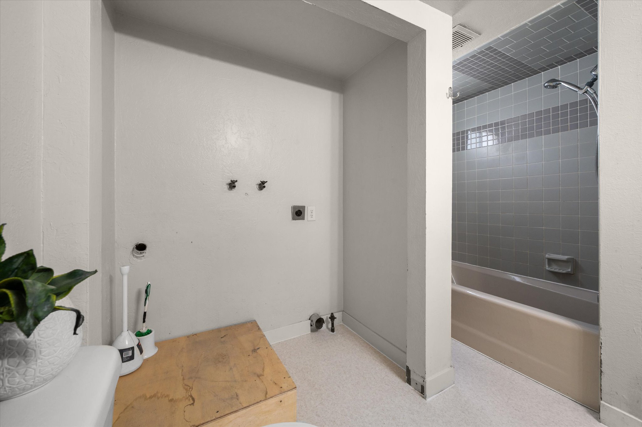 Utility area with washer hookups and a full bathroom featuring a tub with an integrated shower