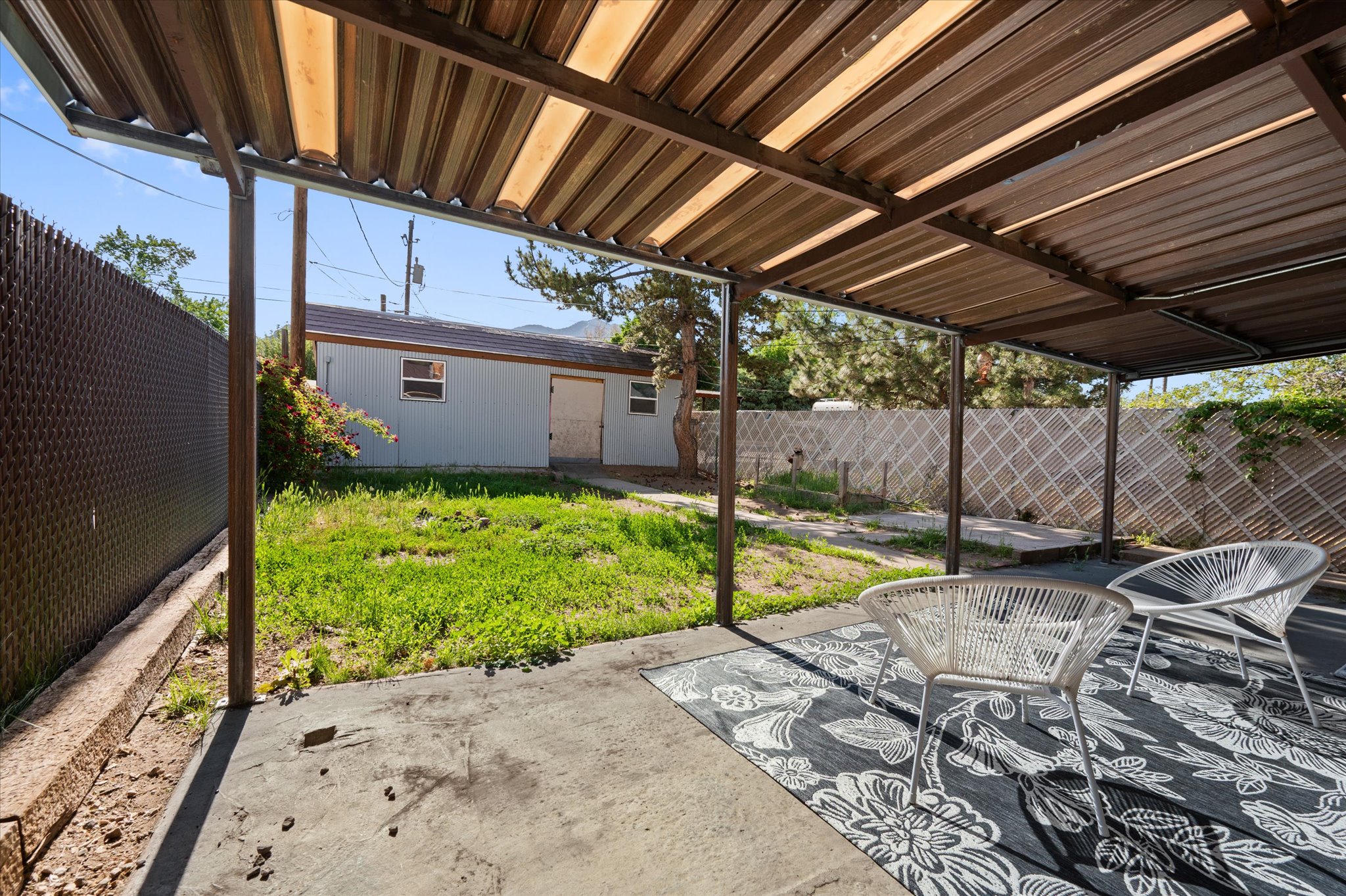 Covered patio featuring a solid concrete floor and a brown metal overhang
