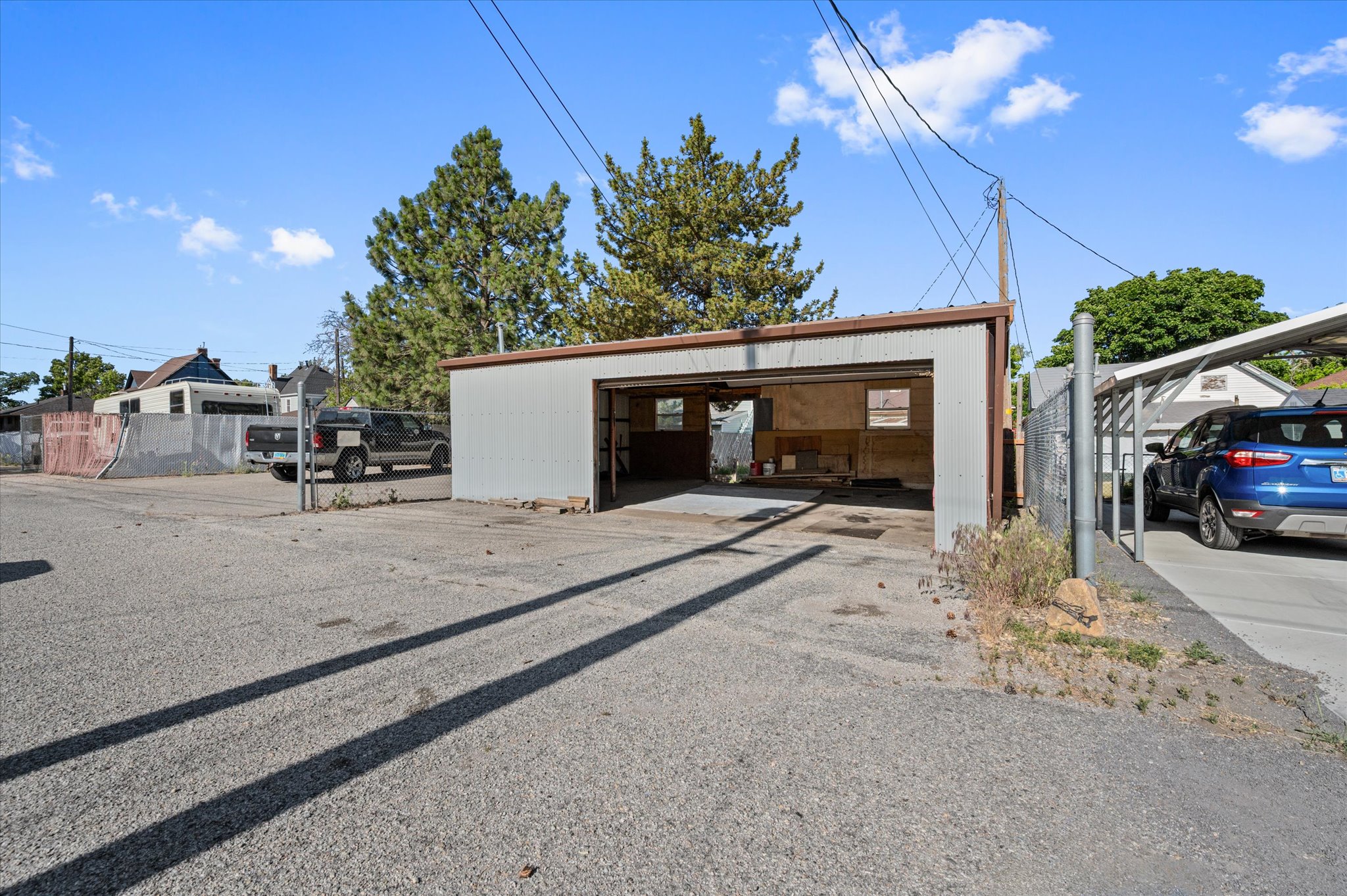 Detached metal garage with an open bay, providing covered parking or storage