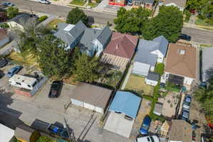 Residential property featuring multiple structures, a paved drive, and a detached garage with a metal roof