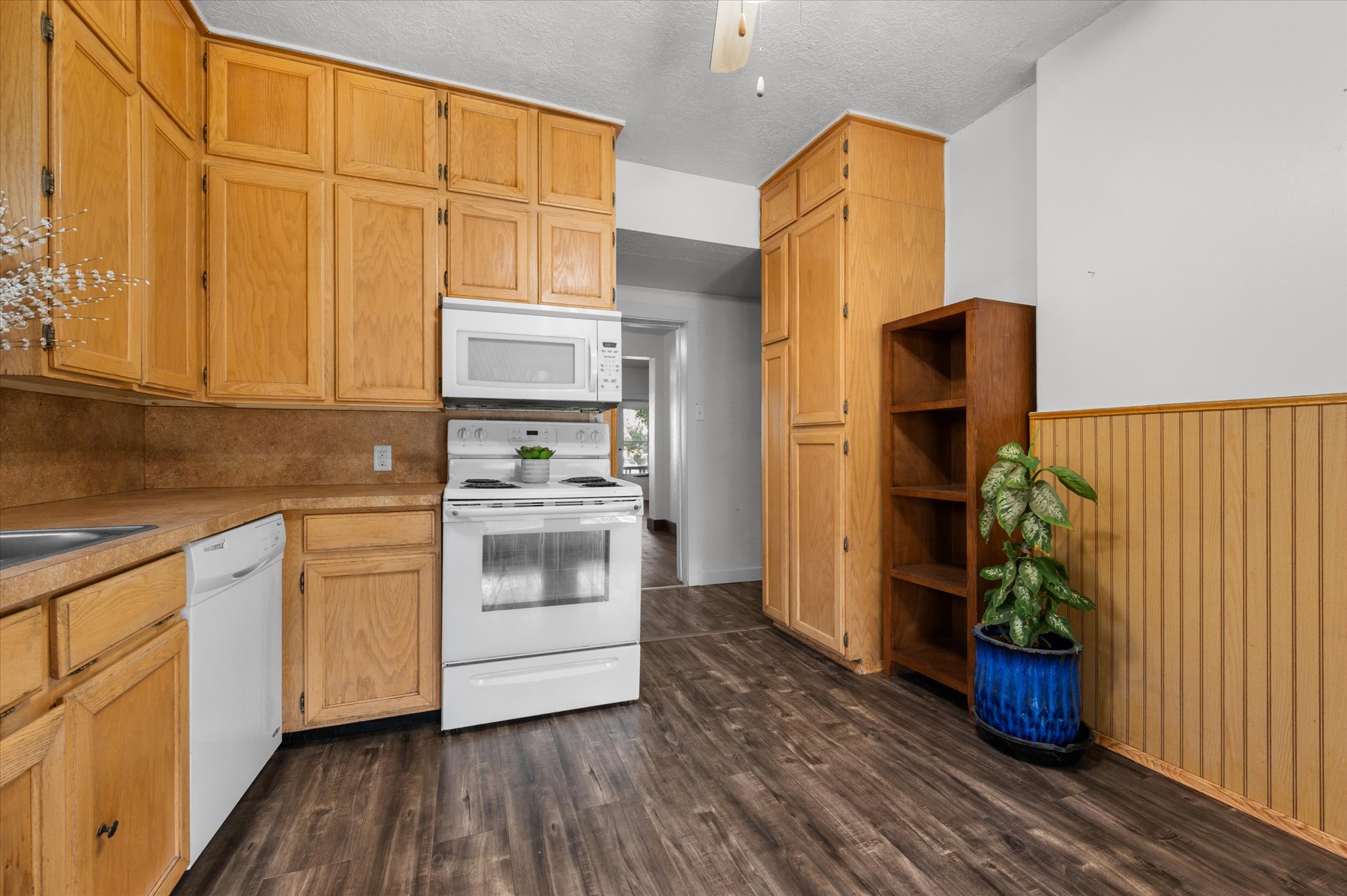 Kitchen featuring wood-finish cabinetry, solid surface countertops, and wood-finish flooring