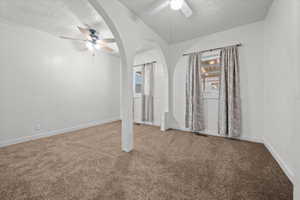 Arched doorways defining distinct spaces, complemented by plush brown carpeting and white wall finishes