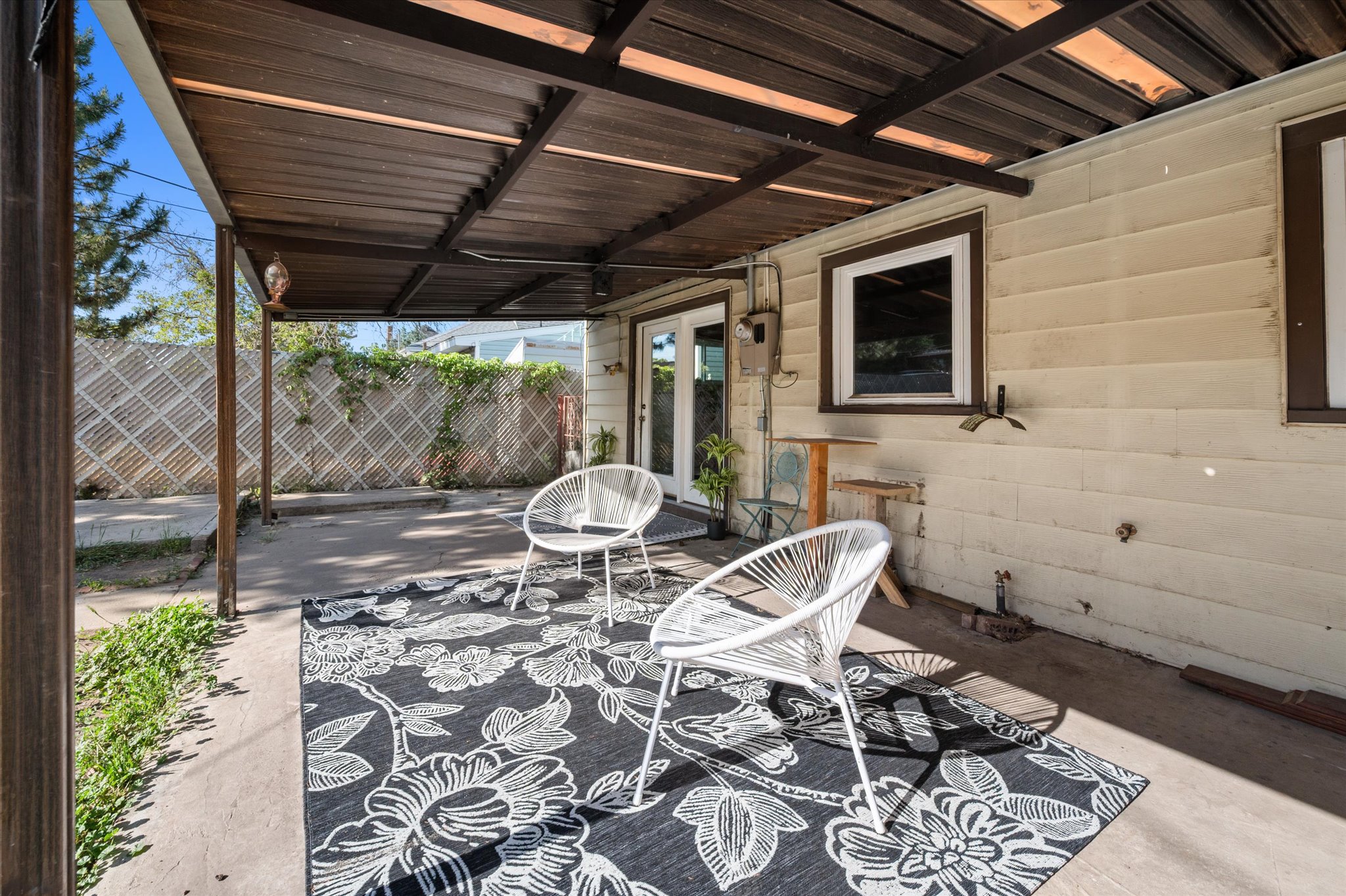 Covered patio area featuring a corrugated metal roof and concrete flooring