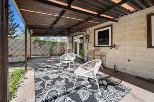 Covered patio area featuring a corrugated metal roof and concrete flooring