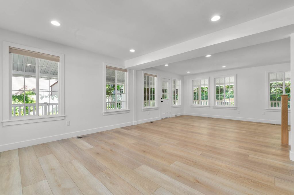 Expansive room featuring wood-finish flooring and recessed lighting