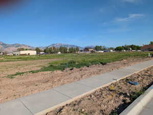 Expansive land parcel featuring new concrete sidewalks and a mountain backdrop