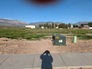 Expansive undeveloped lot featuring a concrete sidewalk at the foreground