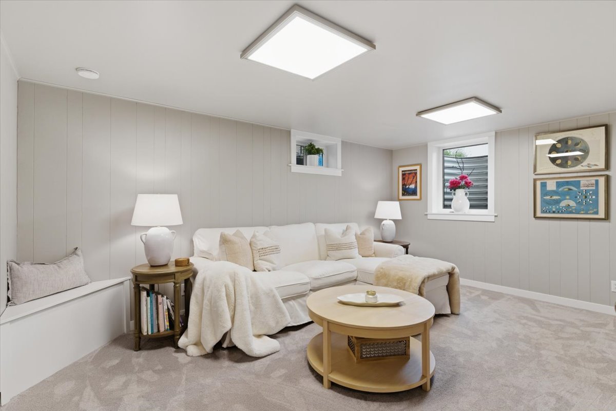 Carpeted recreation room featuring light gray vertical paneling