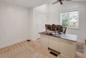 Bright room featuring light wood-finish flooring, white walls, and a window with blinds