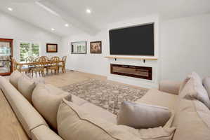 Expansive living area with vaulted ceilings and recessed lighting