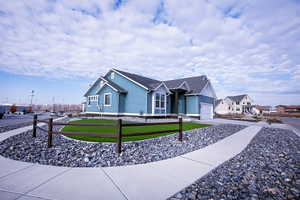 Single-story residence featuring light blue siding with white trim, a dark gray shingle roof, and an attached two-car garage