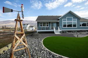 Exterior showcasing a blue-gray siding, a prominent multi-pane window configuration, and a durable dark roof
