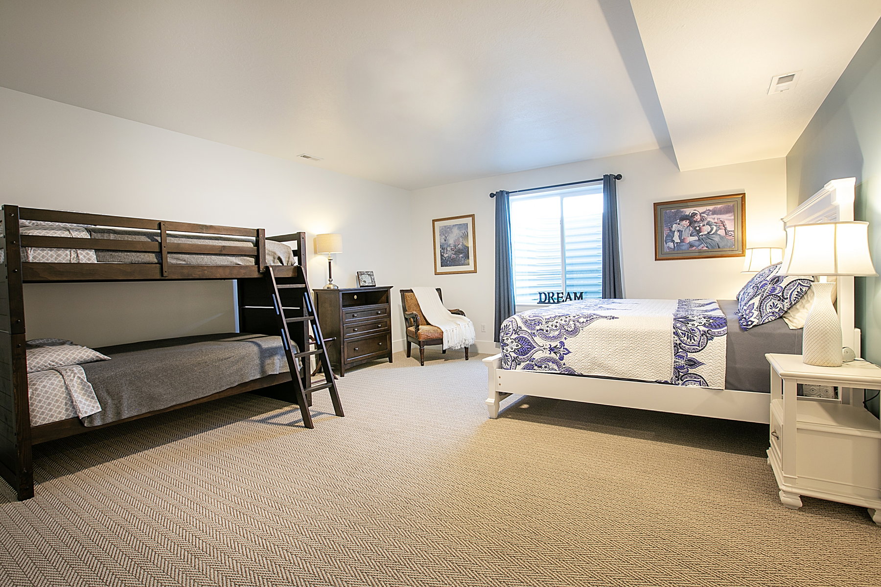 Carpeted room featuring white walls, a single window with blinds and blue curtains, and a painted accent wall