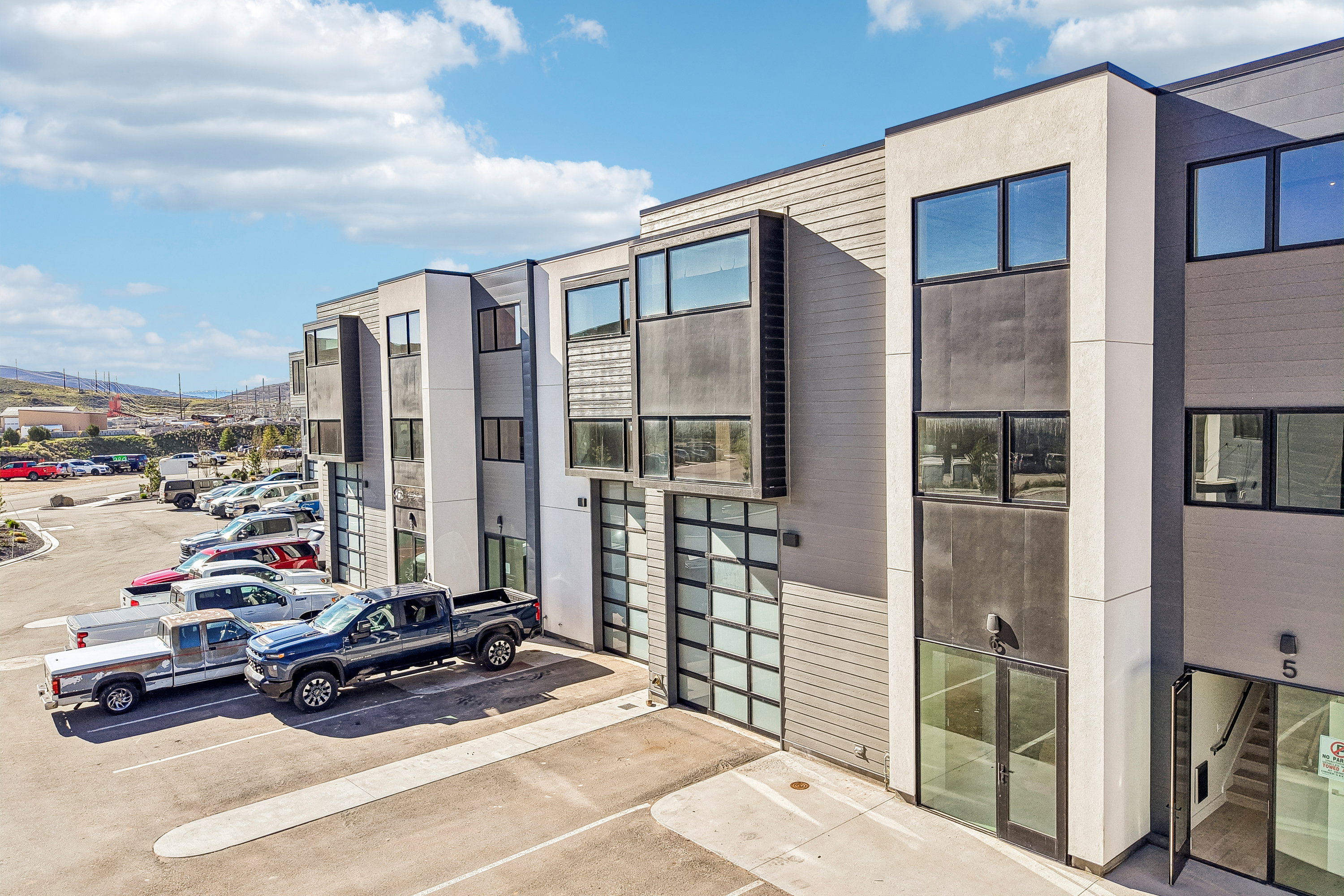 Modern multi-story commercial building featuring a contemporary facade with varied paneling and expansive windows