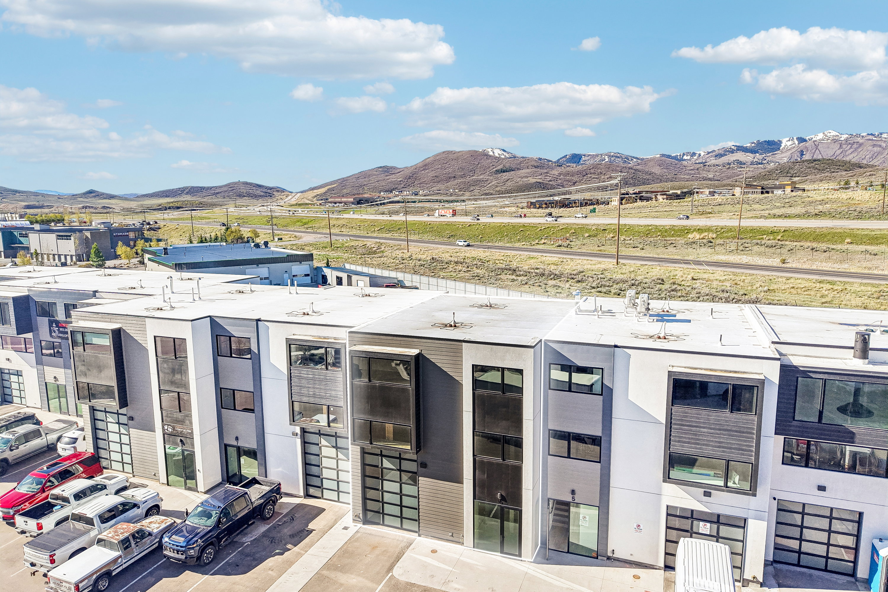 Modern multi-level townhomes featuring mixed-material facades with vertical siding and stucco